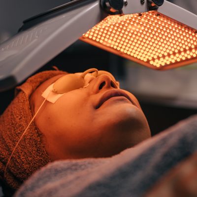 Woman facial cosmetic process with biolight LED laser face skin treatment repair lifting rejuvenation in technology beauty spa